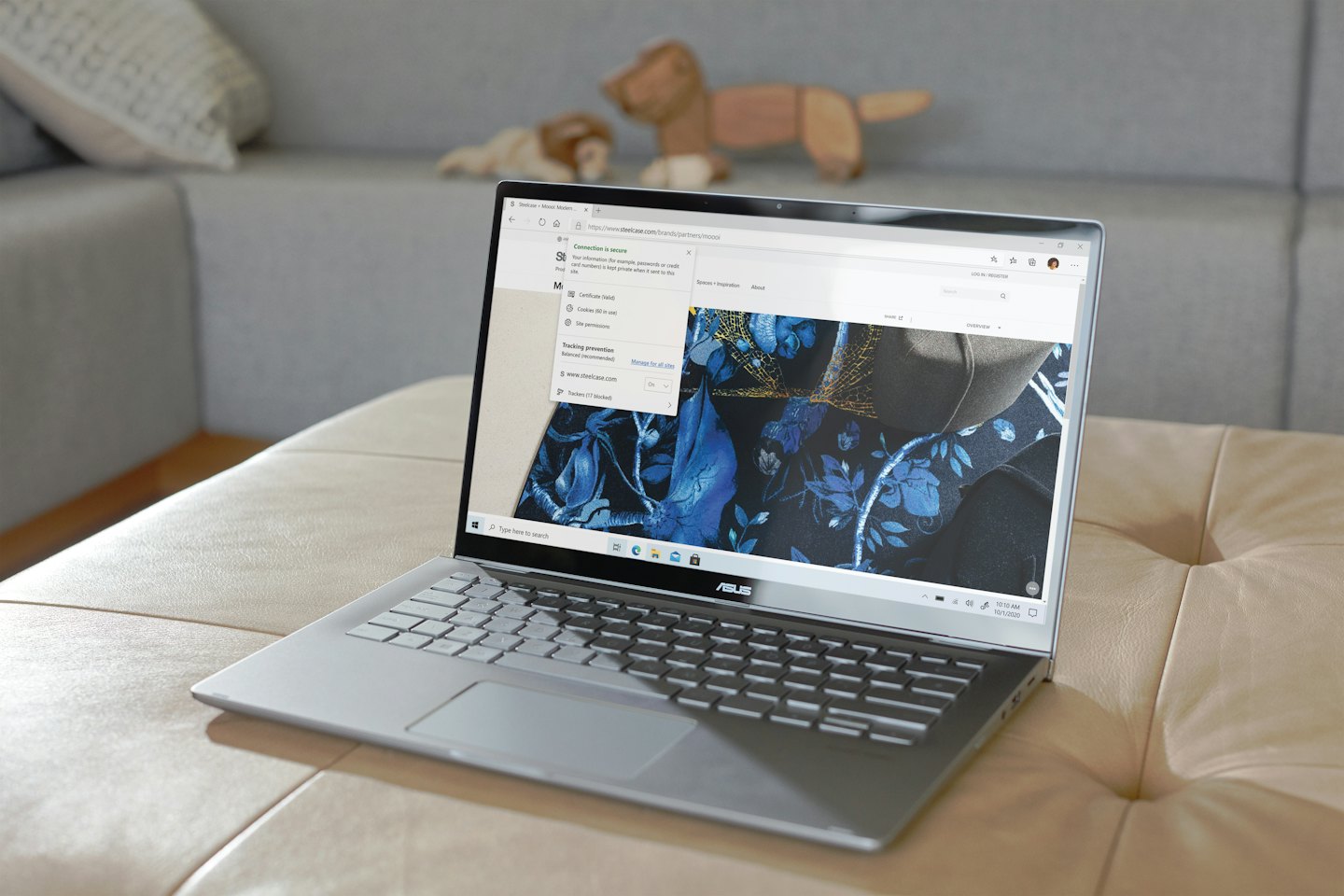 Silver laptop sits on an ottoman displaying a secure connection.